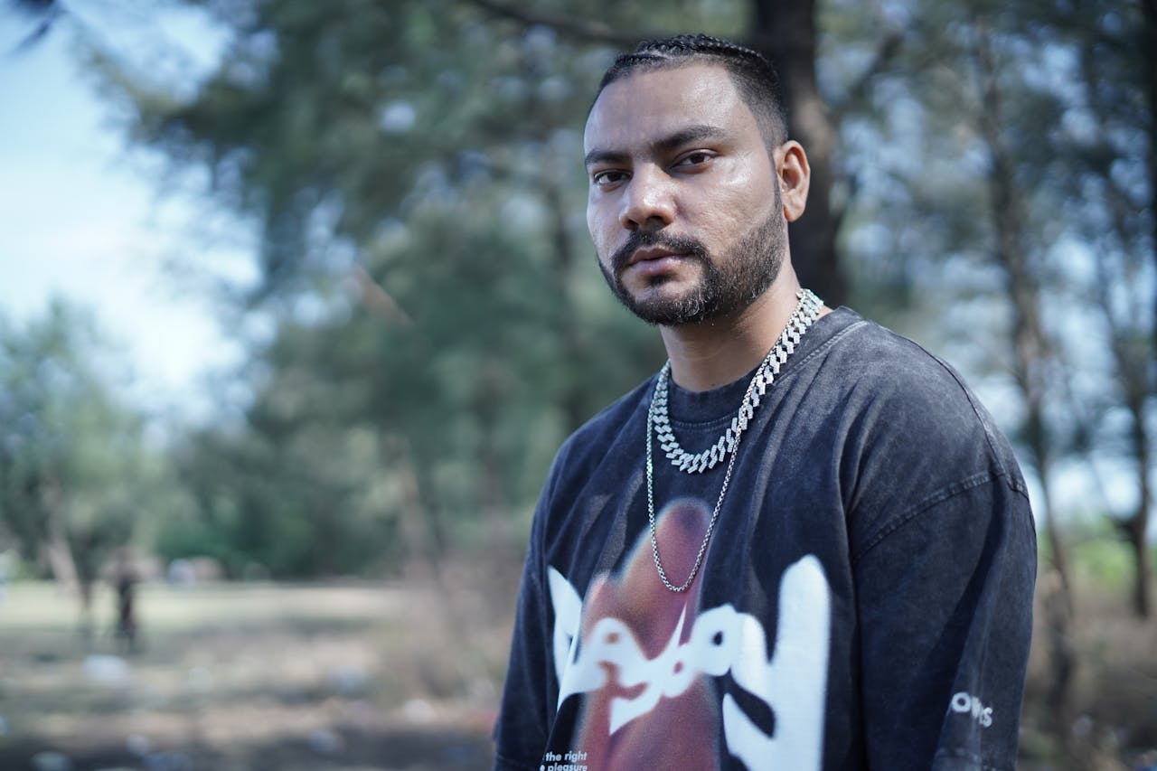 Outdoor portrait of a man wearing a black t-shirt and chain necklace in Mumbai, embodying a modern urban style.