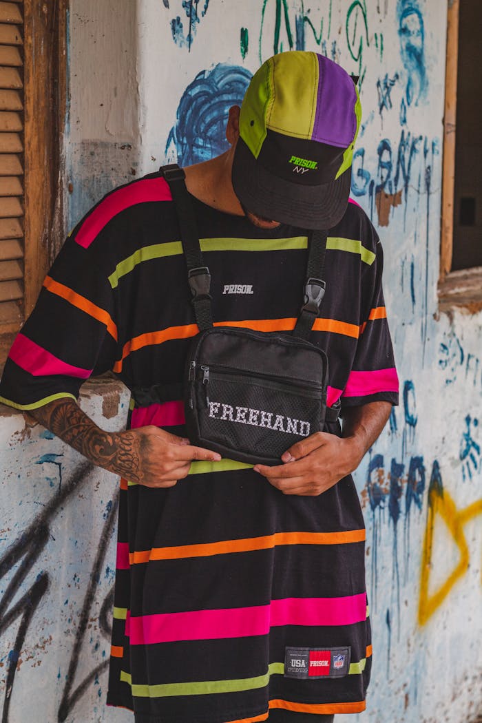 about-02 Tattooed man wearing bold stripes and urban streetwear style.