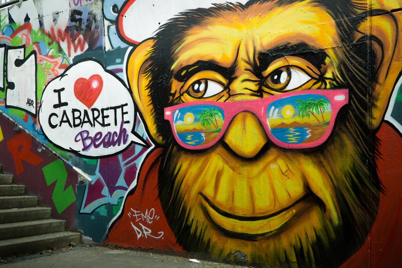 mission-img Colorful street art of a monkey with sunglasses on stairs, featuring Cabarete Beach text.